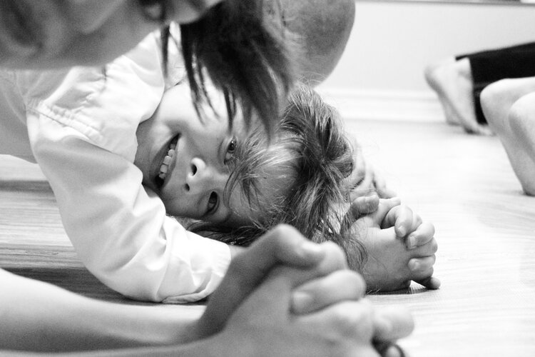 a young child in a karate gi bowing his head during class