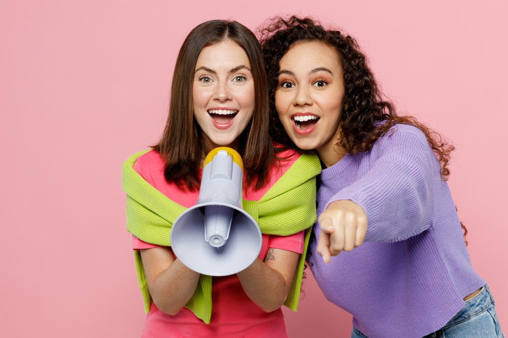 Two Well Dressed Women with a Blowhorn Promoting Word of Mouth Marketing Two Well Dressed Women with a Blowhorn Promoting Word of Mouth Marketing