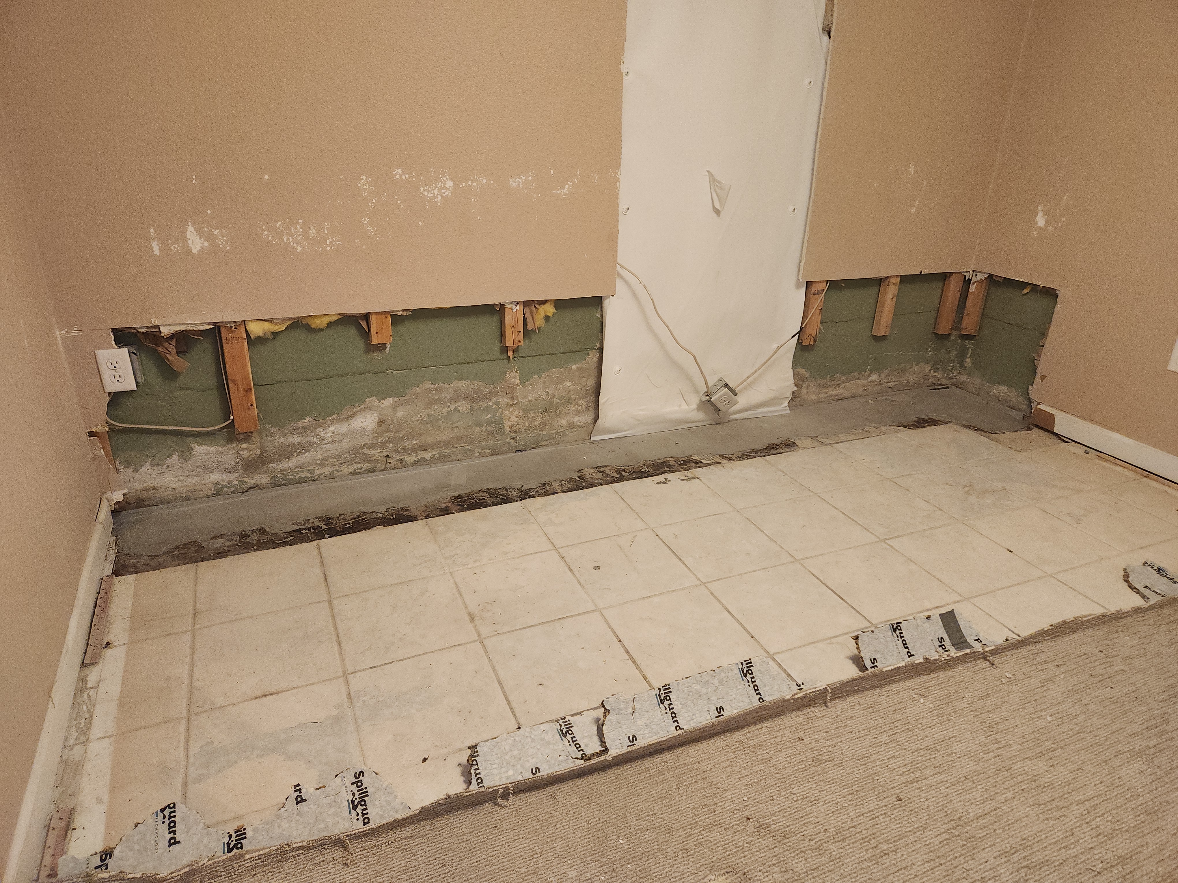 Basement flood damage in Denver showing a 'flood cut' where the bottom two feet of drywall were removed to expose the concrete foundation and wooden studs for drying. Basement flood damage in Denver showing a 'flood cut' where the bottom two feet of drywall were removed to expose the concrete foundation and wooden studs for drying.