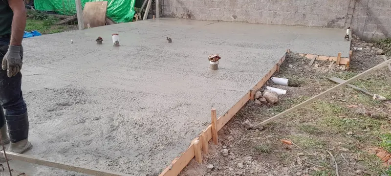 Platea de hormigón recién colada con el encofrado de madera en el borde.