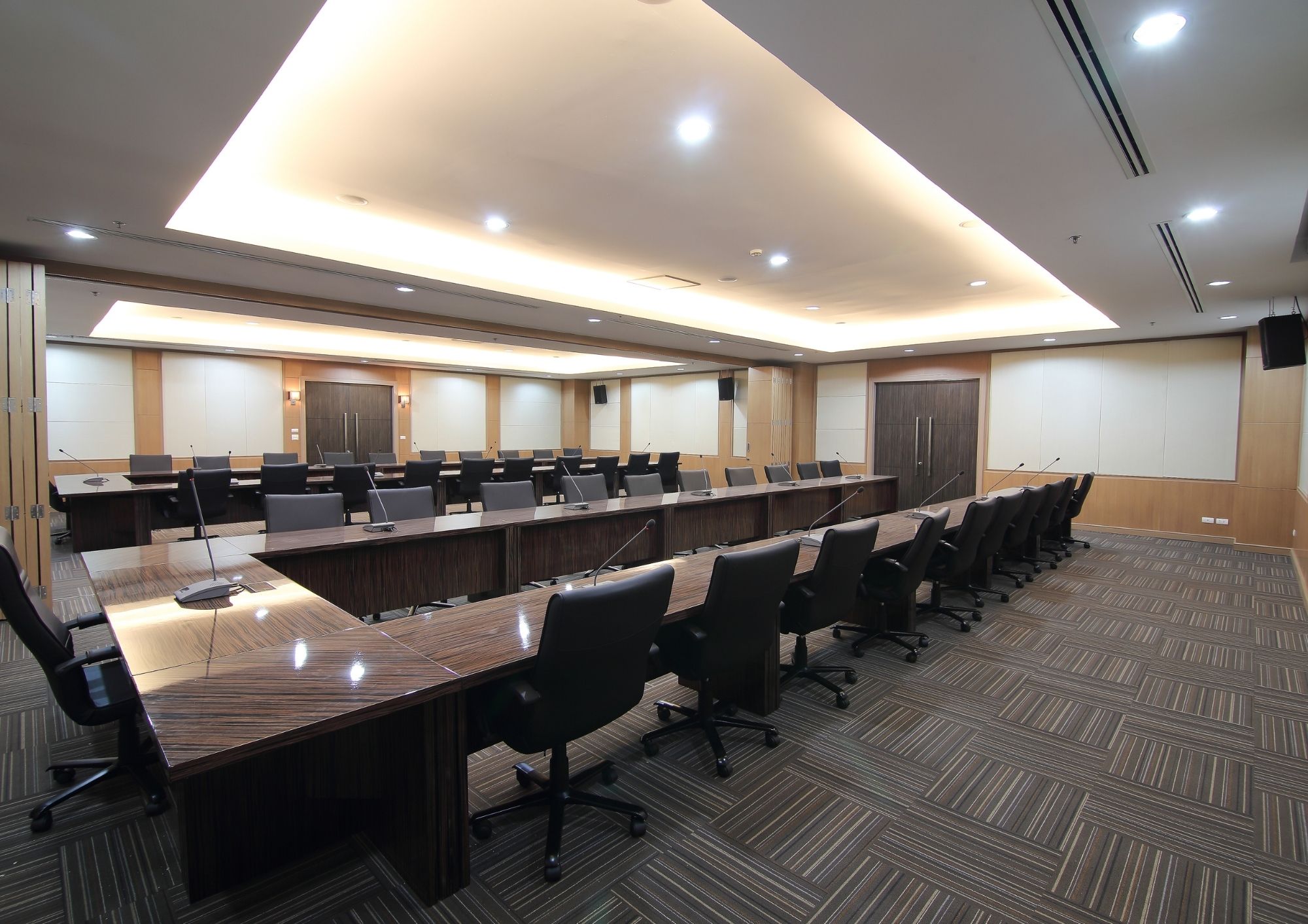 Boardroom table with ceiling microphones and integrated conference audio in a commercial office