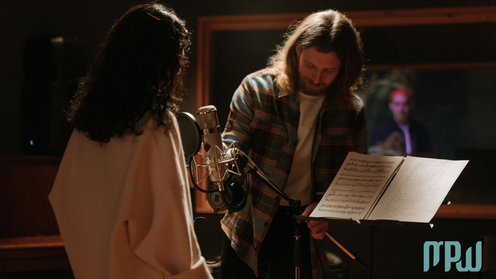 Singer and producer preparing a vocal recording session in a professional studio