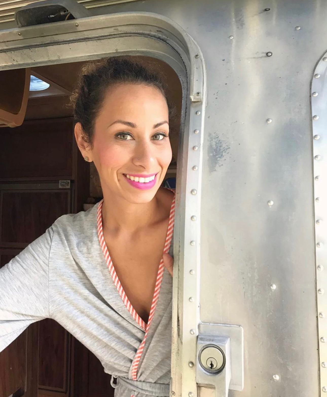 Jules De Jesu Fritz Puerto Rican woman opening door of vintage airstream camper in robe with makeup beautiful