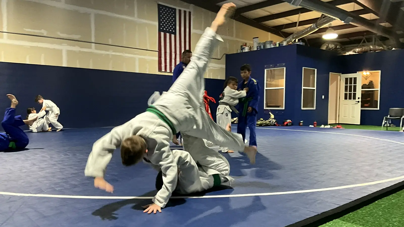 Young judo student landing a hip throw on a partner during practice