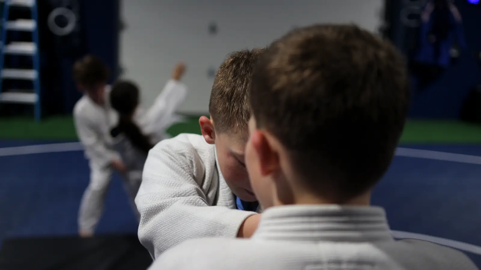 Two young judoka gripping each other's gis during practice