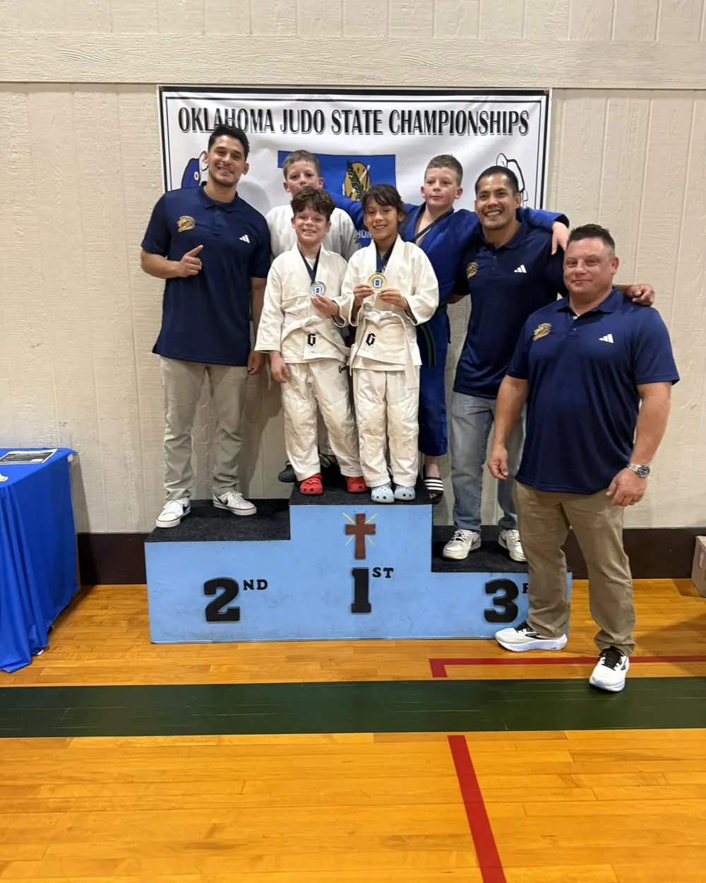 Dominion Academy judo students and coaches on the podium at the Oklahoma Judo State Championships
