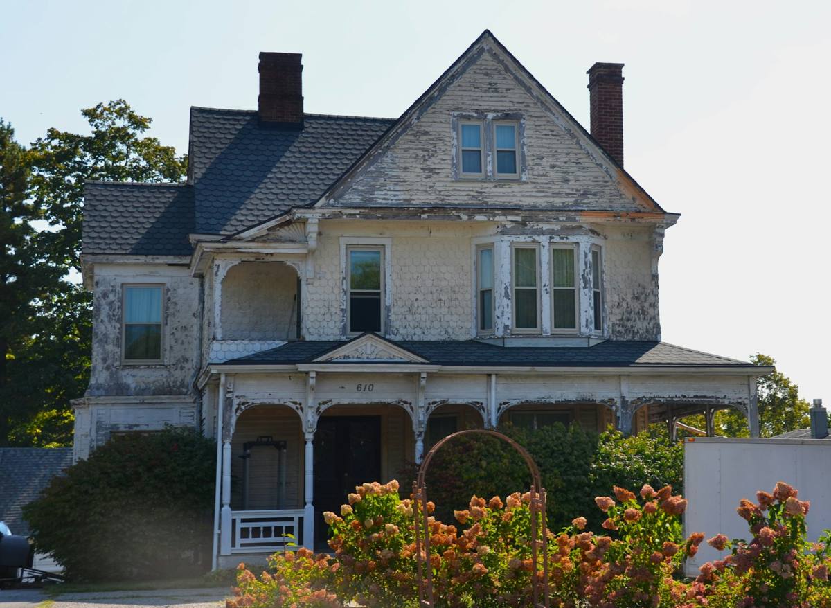Older two-story house with weathered, peeling paint (stock photo)