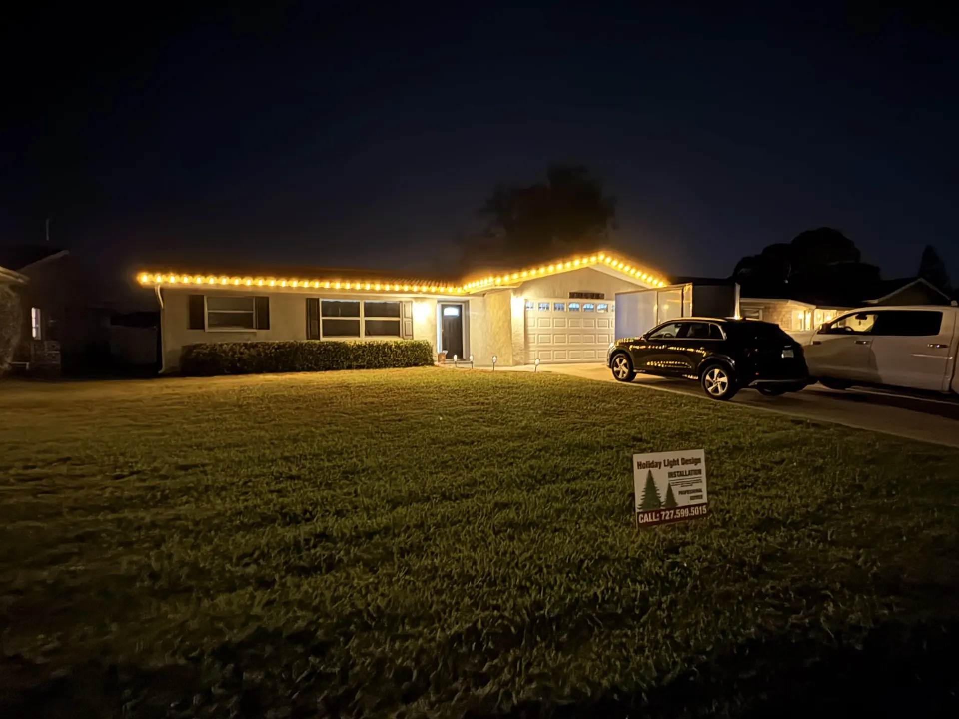 Professional installer placing red and white roofline lights