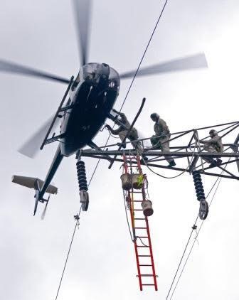 ARC helicopter crew performing power tower maintenance