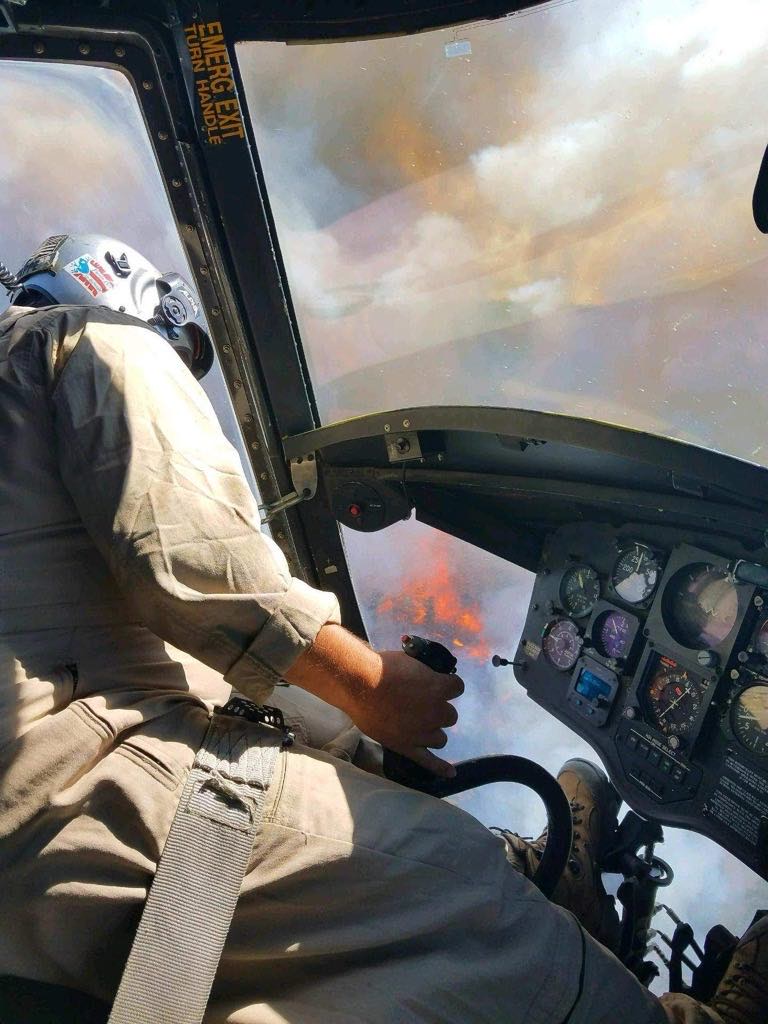 Helicopter performing water drop during aerial firefighting operations
