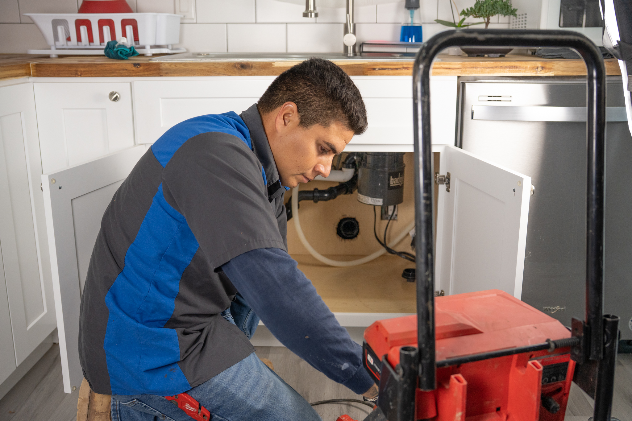 Setting up drain unclog tool under sink