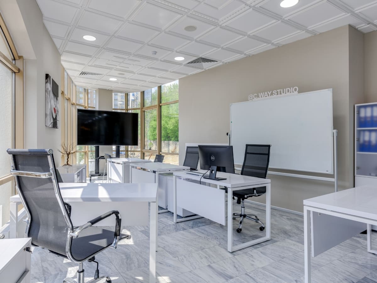 Bright and clean office with large windows, sleek desks, and ergonomic chairs, representing high-quality office cleaning and maintenance in Napa.