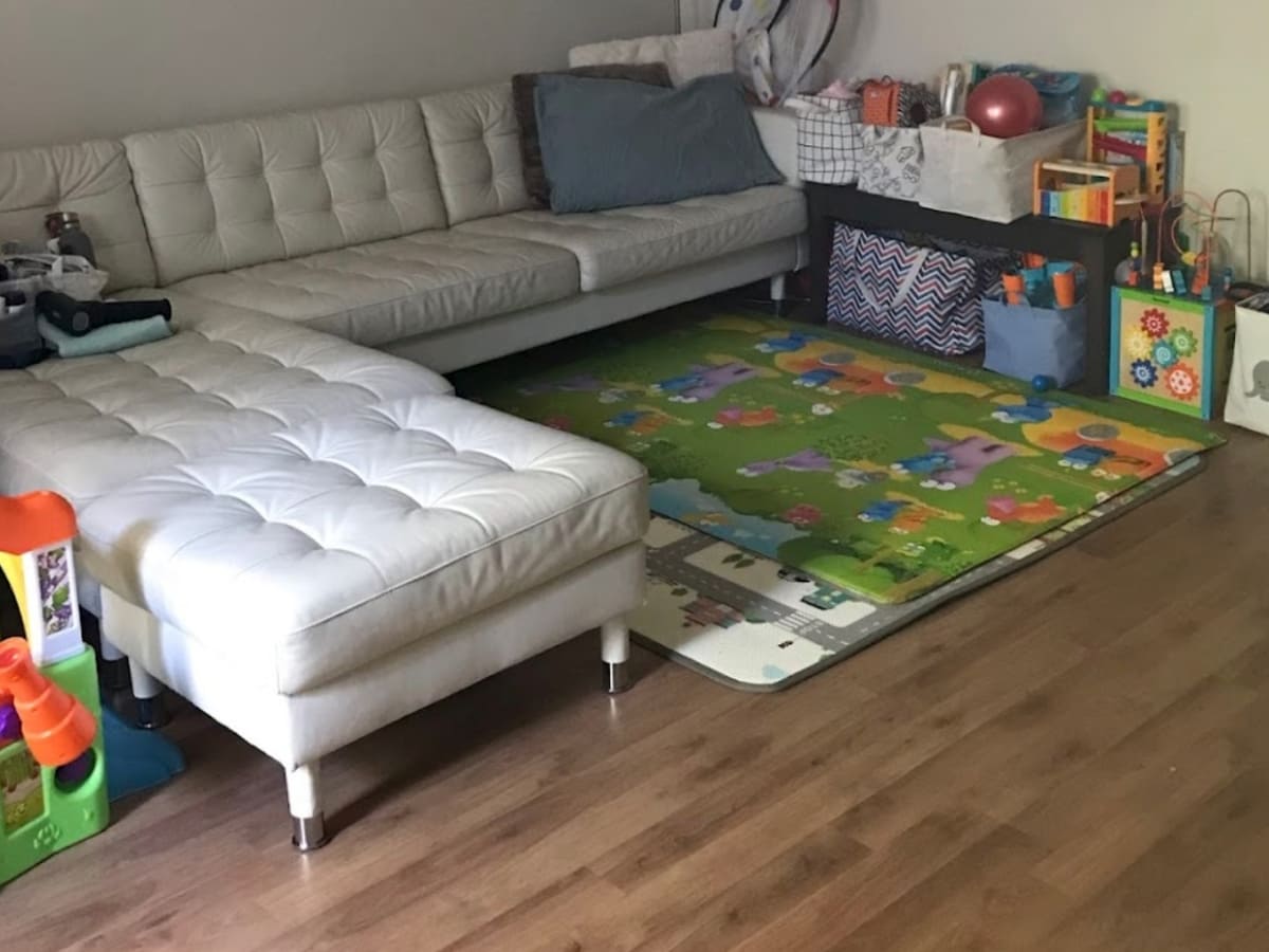 Children’s play area with a white sectional sofa, toys, and a colorful play mat, highlighting thorough and organized living room cleaning in Concord.