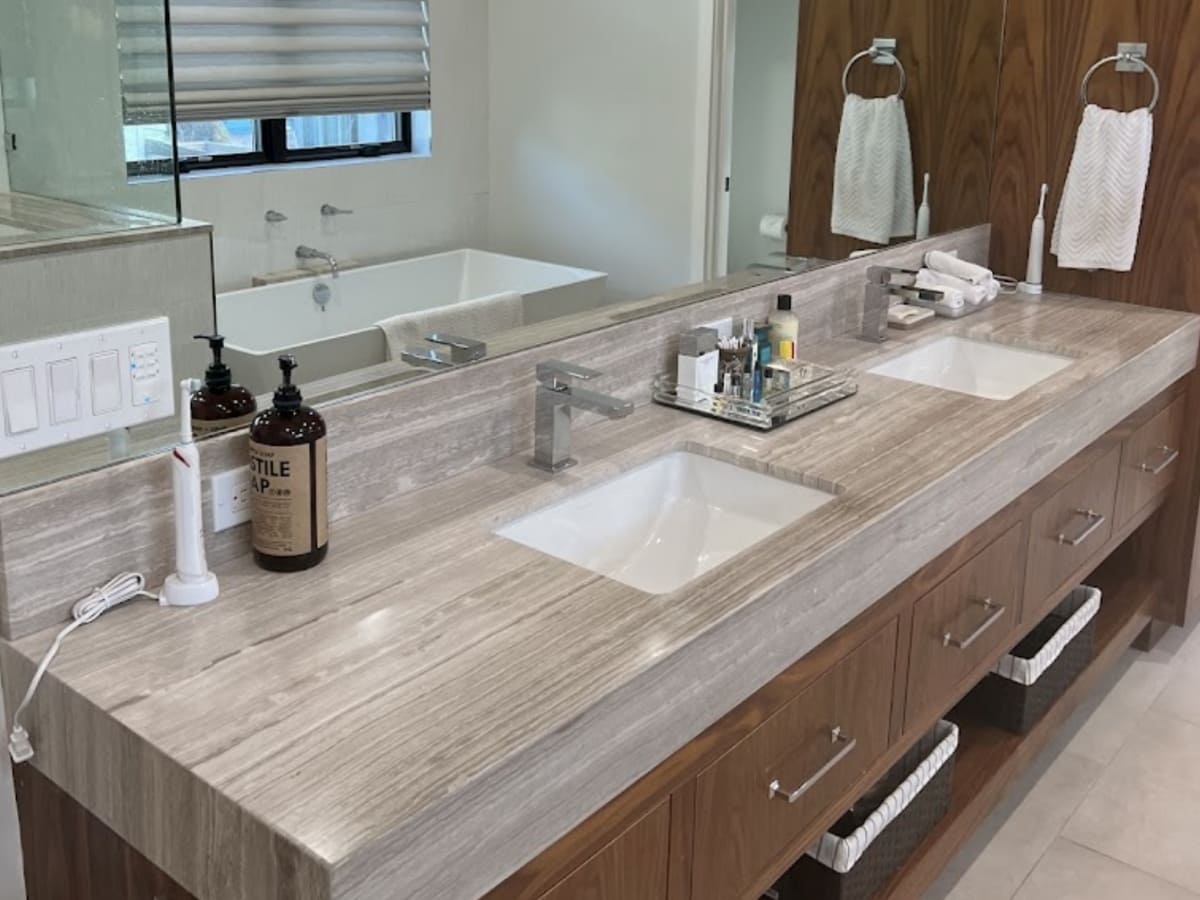 Modern double vanity bathroom with a wood finish, featuring dual sinks, a large mirror, and contemporary fixtures.