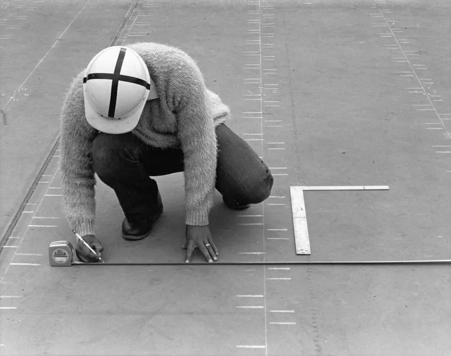 Worker measuring a site with tape and pencil during a consultation walk