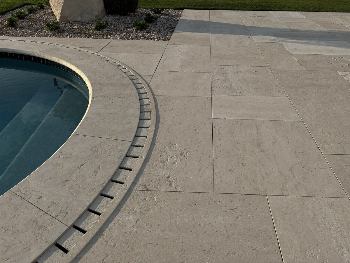 Travertine paving laid beside a lawn area