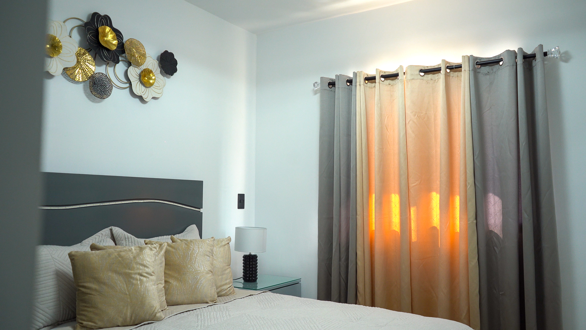 Bedroom with gray headboard and gold accent pillows