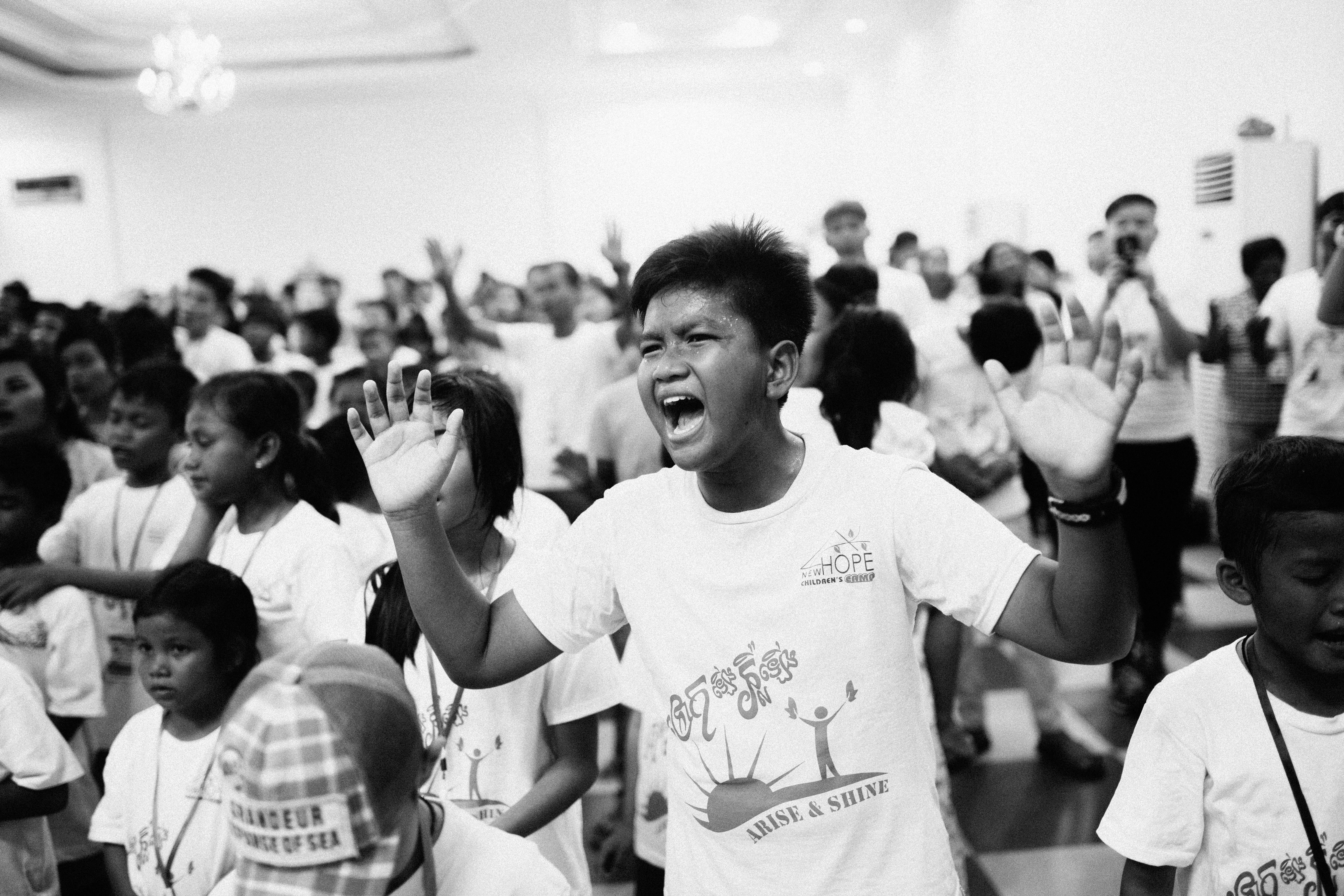 Child worshiping with hands raised at camp