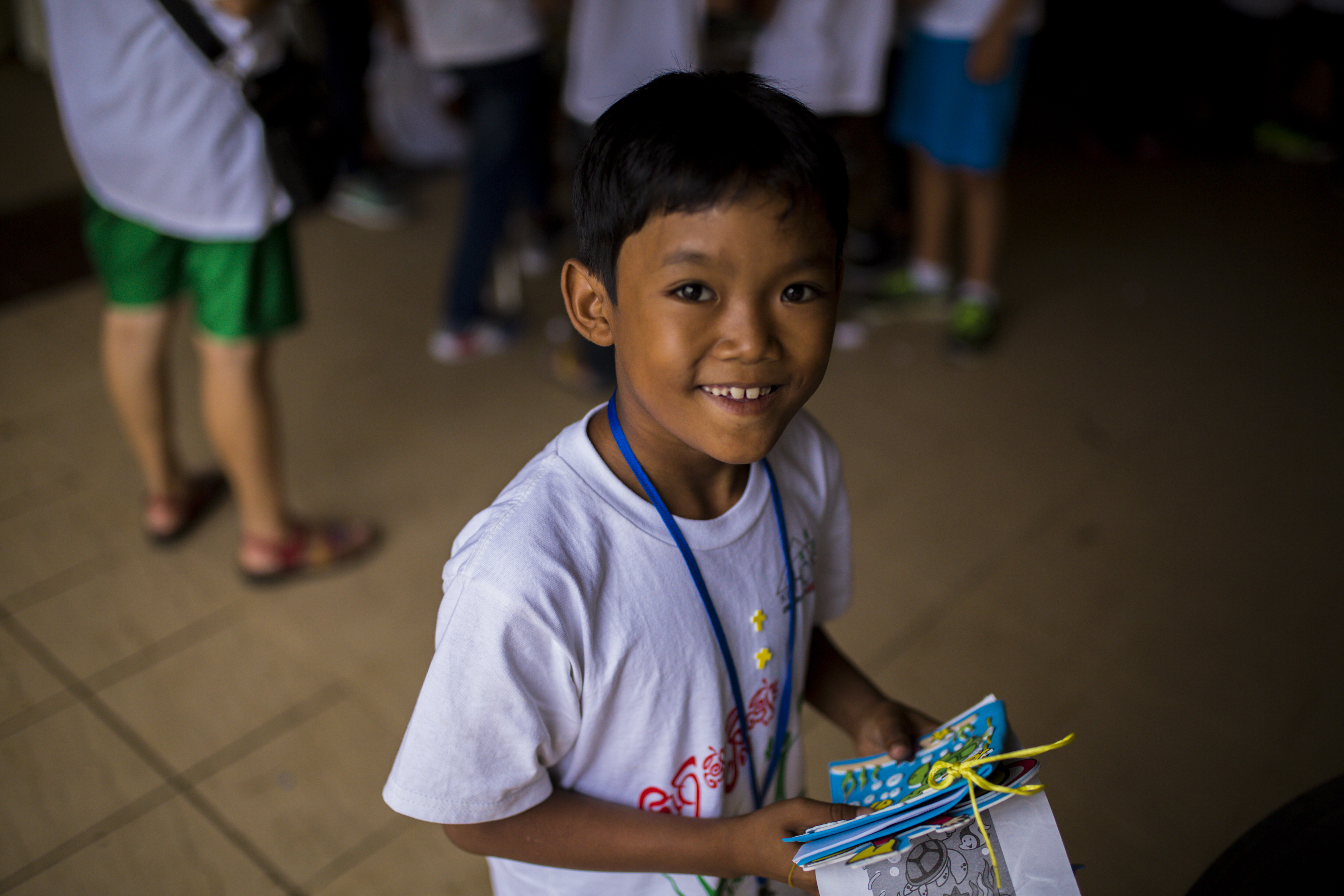 Boy smiling holding a gift bag at camp