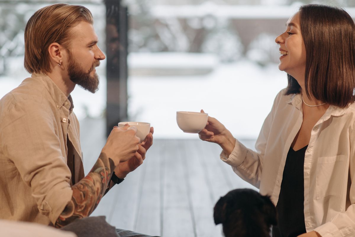 Two people laughing together over coffee.