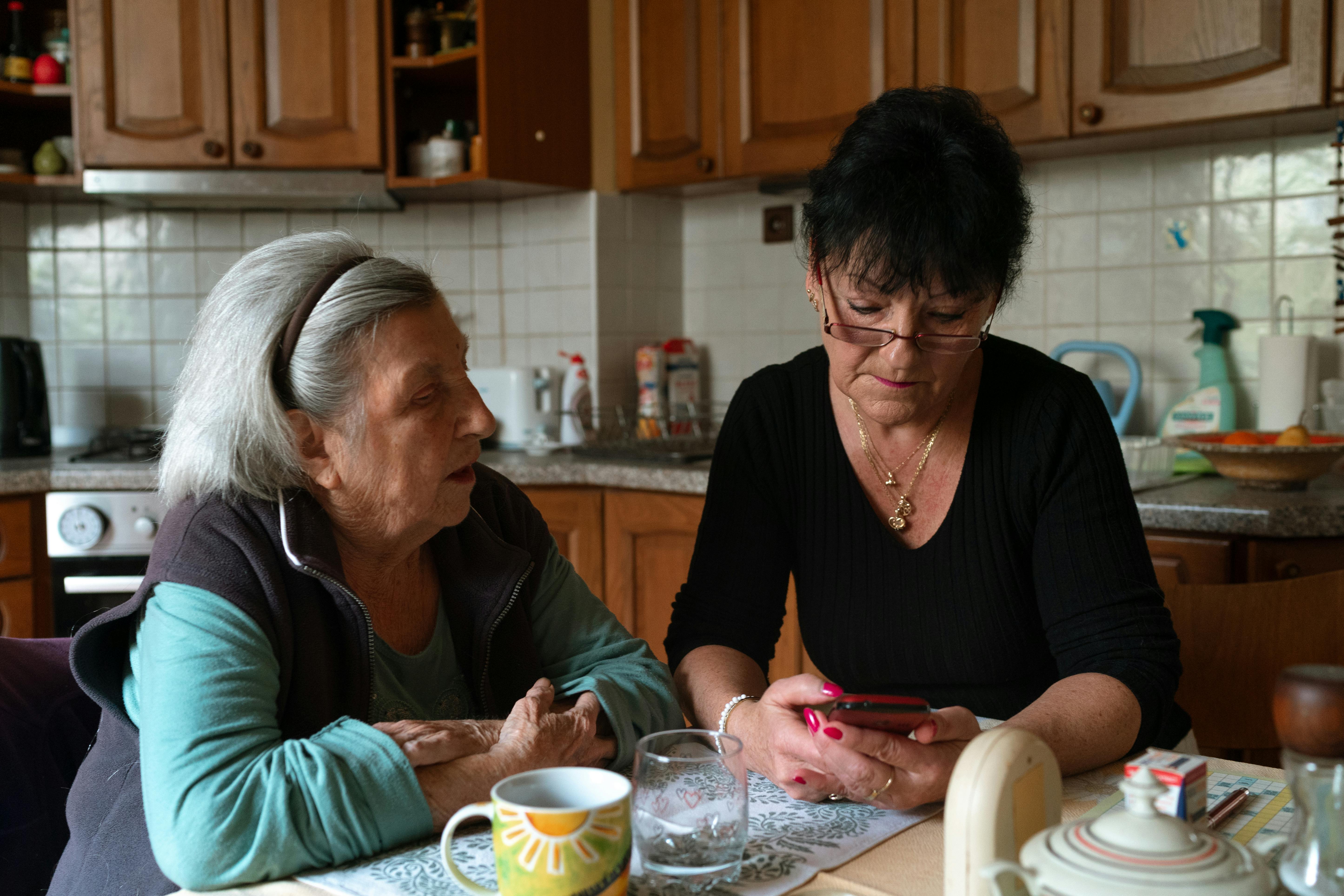 Home care aide helping a senior woman in her kitchen through the Medicaid Home Services Program
