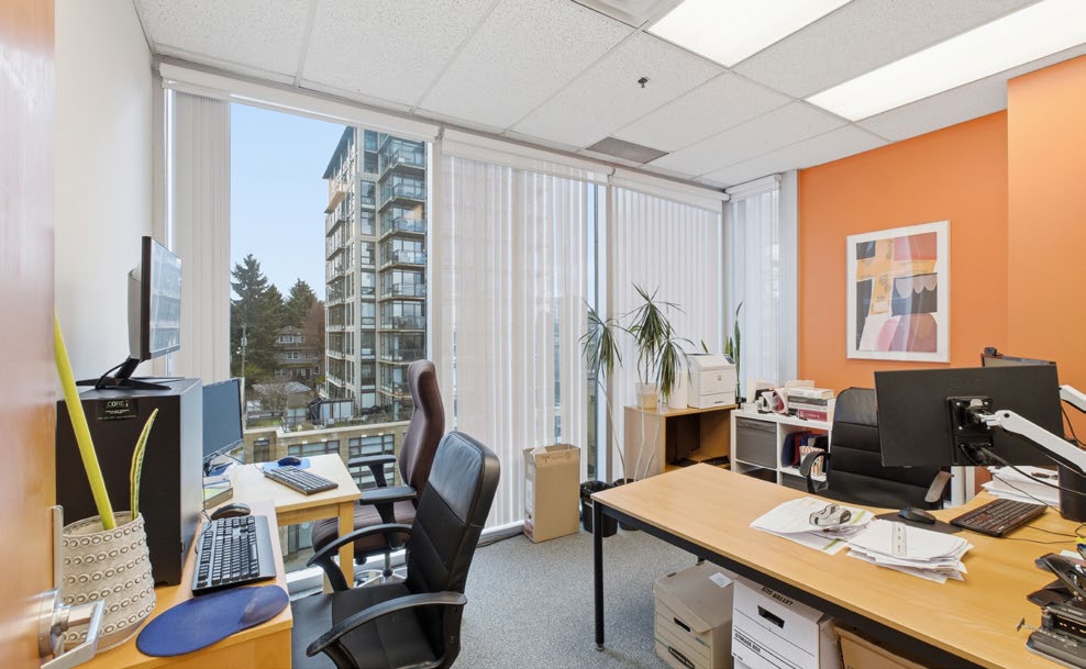 Private office with orange accent wall and city view