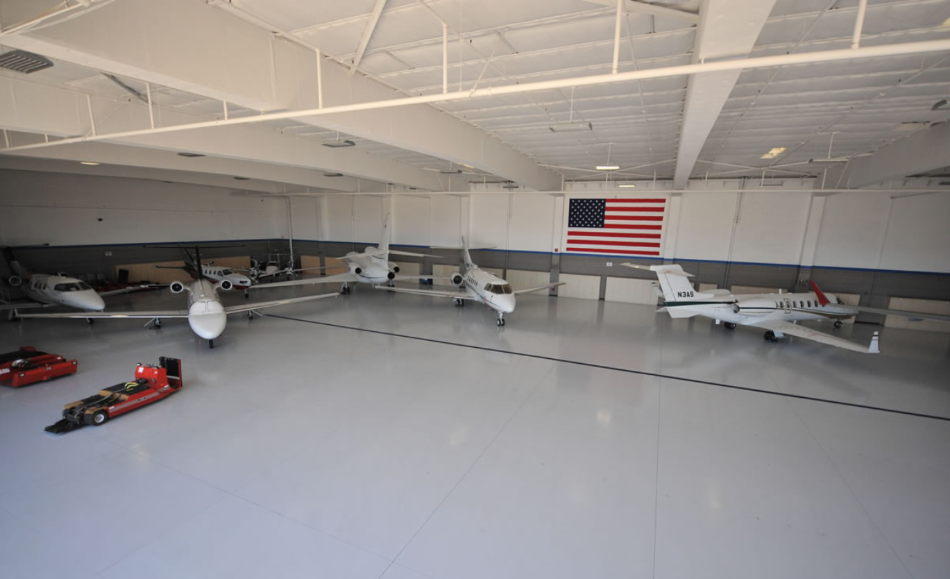 A white car in a garage with a finished floor