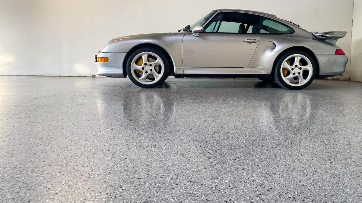 A white car in a garage with a finished floor