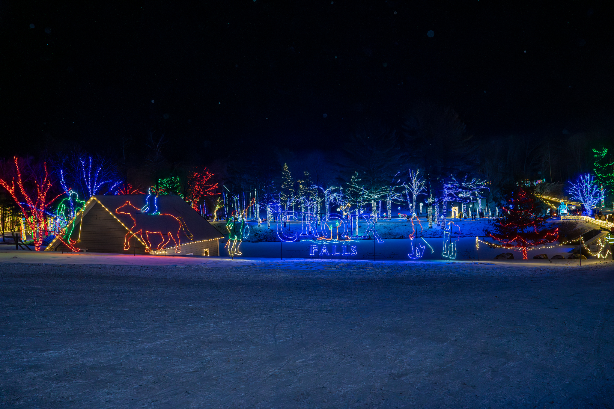 Guests gathering by the fire and sledding under the lights