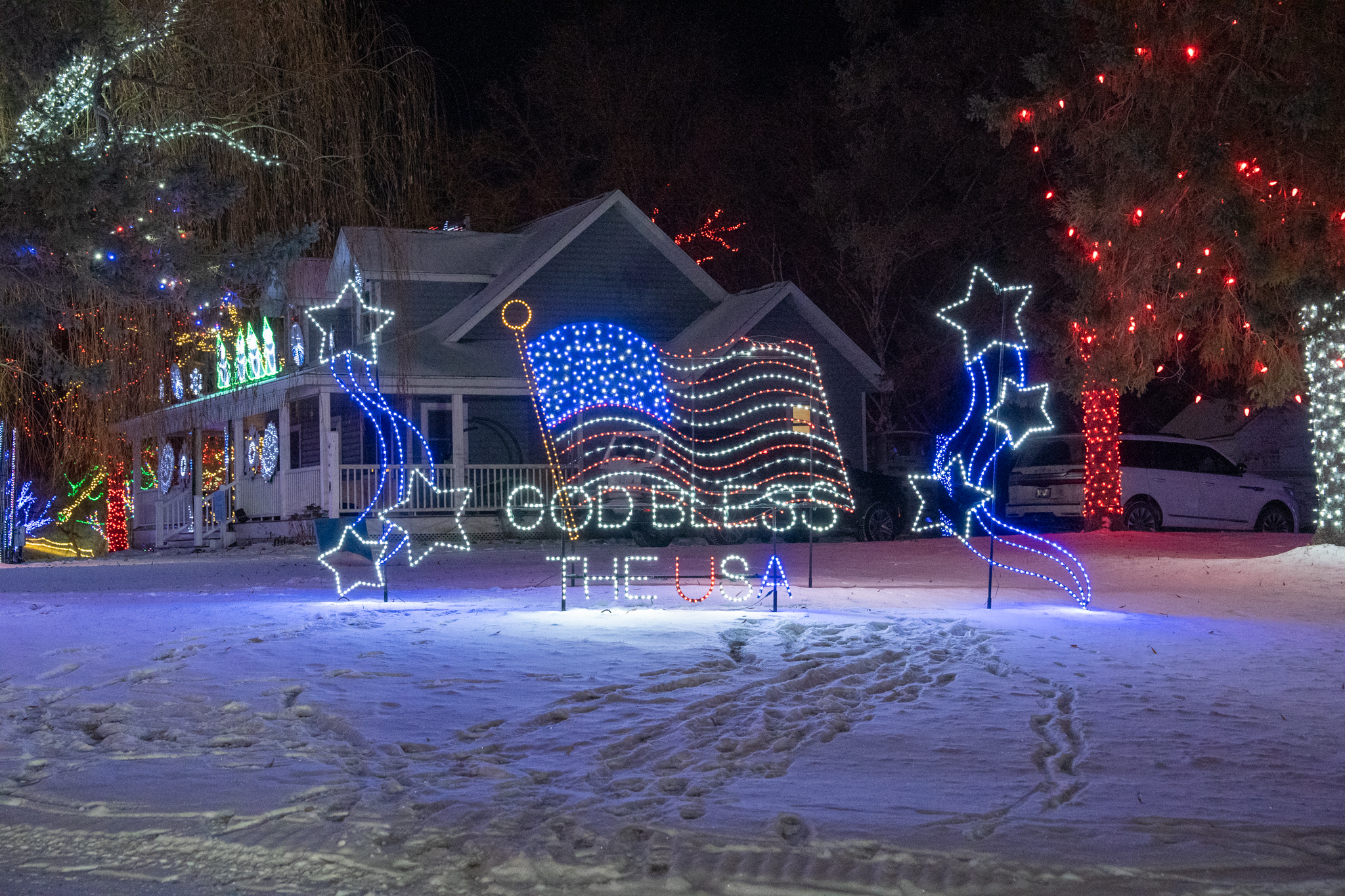 Lit-up house with a glowing USA sign out front at Miracle at Big Rock