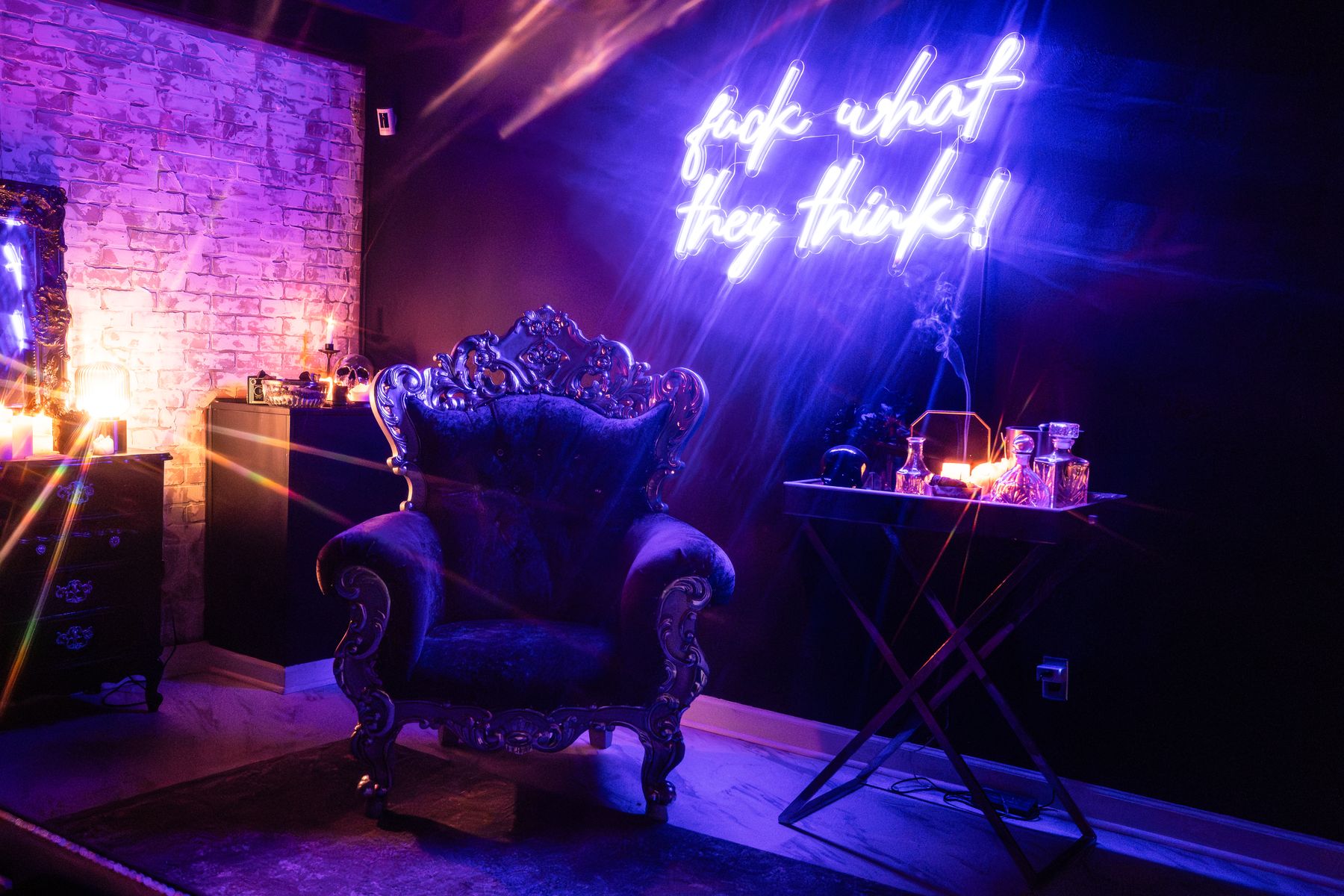 The neon lounge with a velvet throne under the fuck what they think sign at LeZandra Photography, a boudoir studio in Norfolk, VA