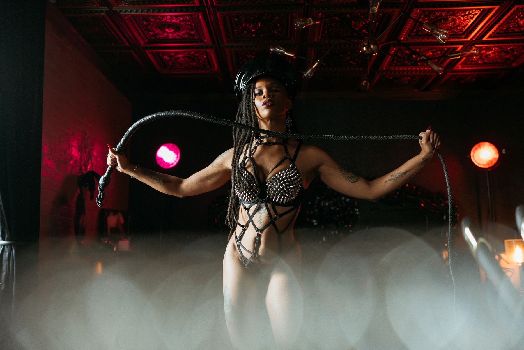 Dominatrix style boudoir portrait with a whip and spiked harness, gothic boudoir in Norfolk, Virginia