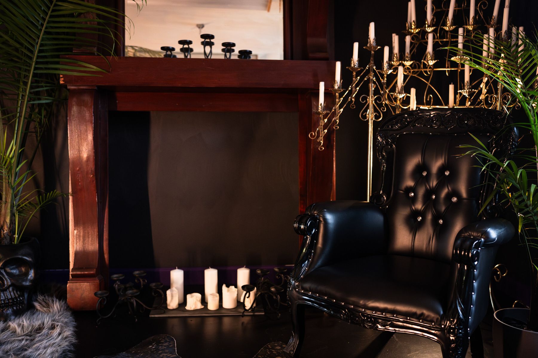 Candlelit fireplace mantel with a gold candelabra and black leather throne at LeZandra Photography, Norfolk, VA