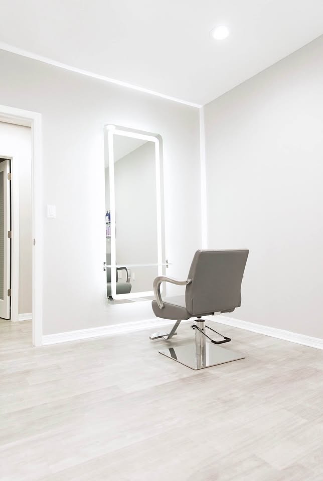 Actual Lavish styling room with illuminated mirror, styling chair and tall window