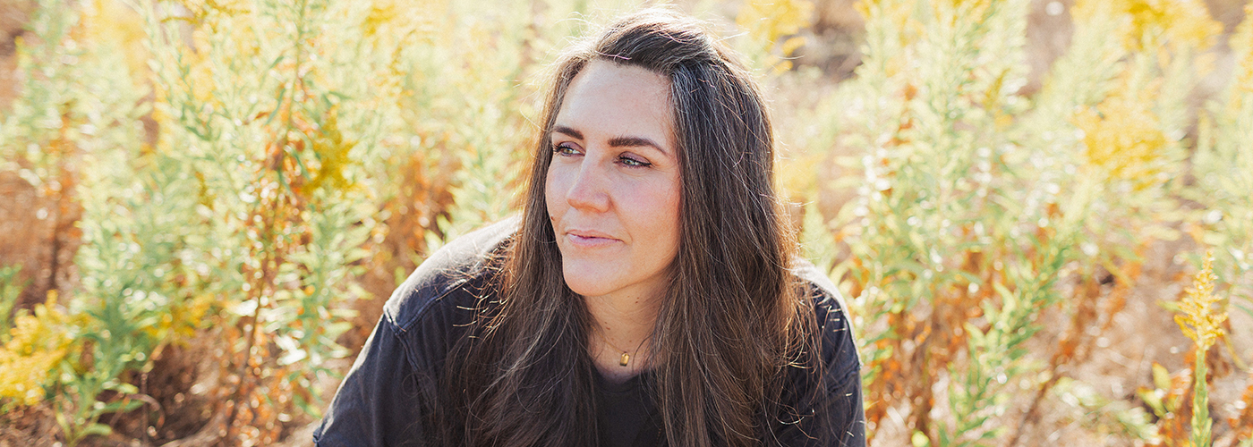 Ali Brown sitting in a golden field