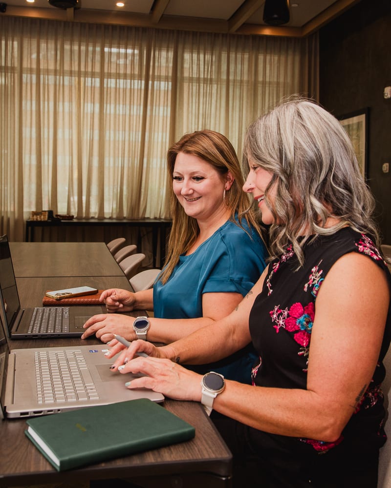 Amber Ell and Lindsey Kaupp working side by side at their laptops
