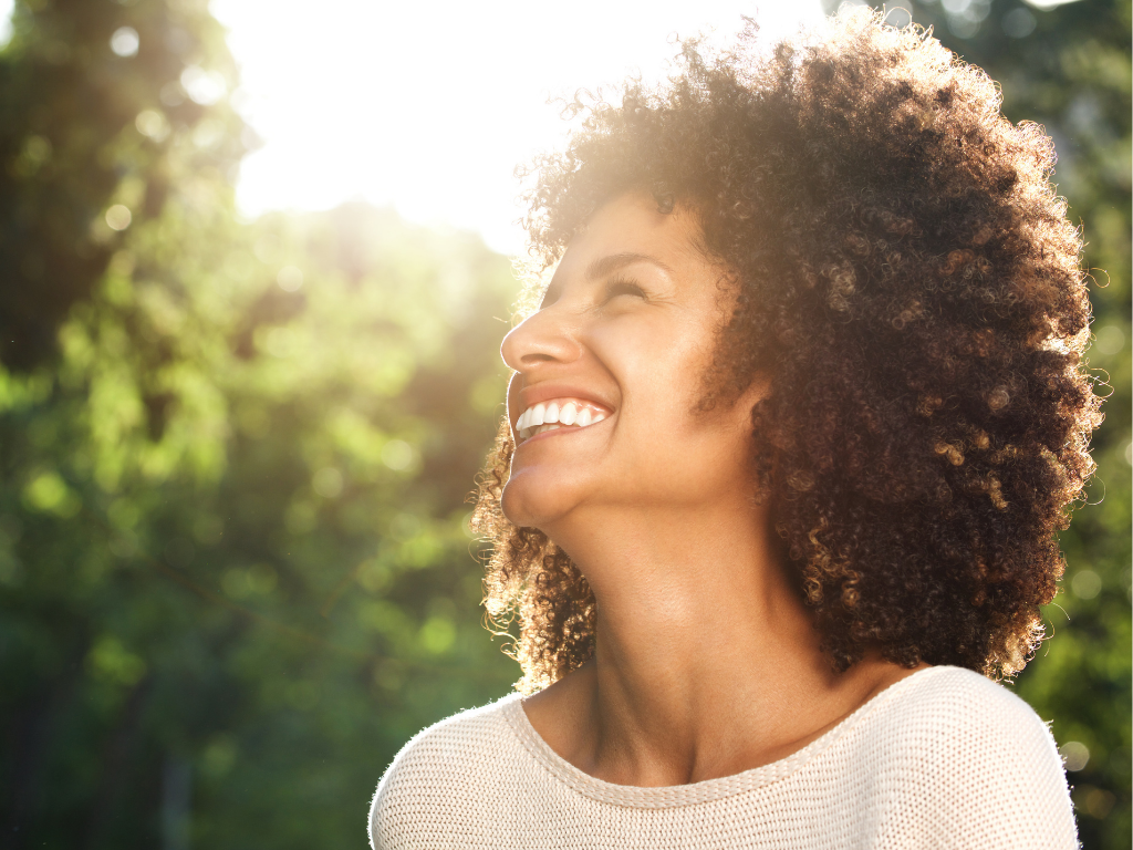 Woman smiling outdoors, confident and free