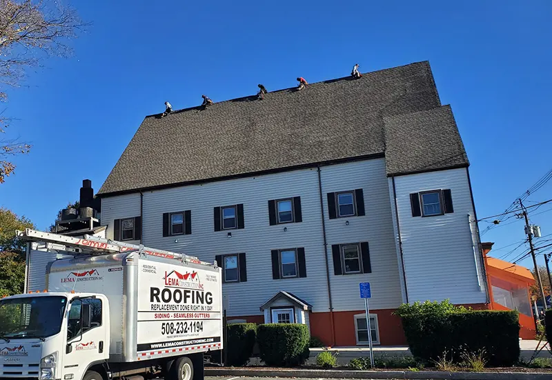 Roofing repair in MA team fixing shingles