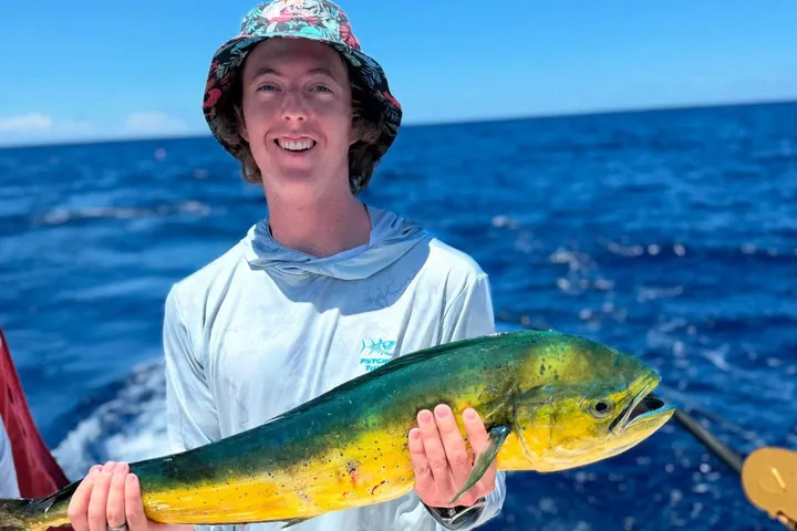 Happy angler holding a mahi-mahi on a RingMaster Charters half-day trip off Pompano Beach, Florida.