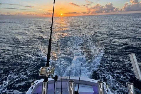 Sunrise wake and trolling spread from the stern on a full-day offshore charter near Pompano Beach.