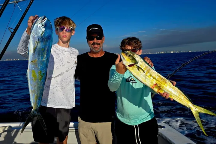 Family showing a mahi-mahi on deck during a 3/4-day offshore charter off Pompano Beach, Florida.