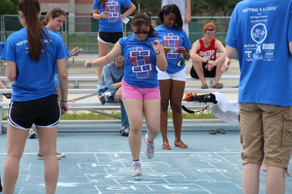 A player hops the grid as fellow Recess Olympians watch at a Hopping 4 A Cure Hopscotch Tournament.