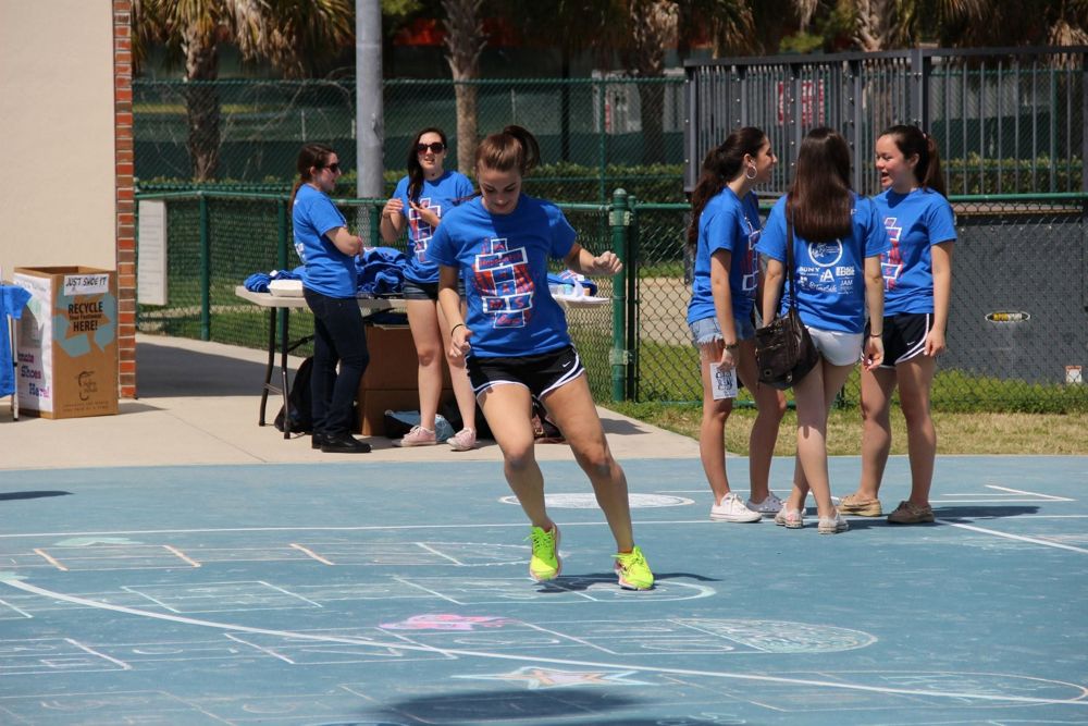 A Recess Olympian hops toward Home as teammates look on.