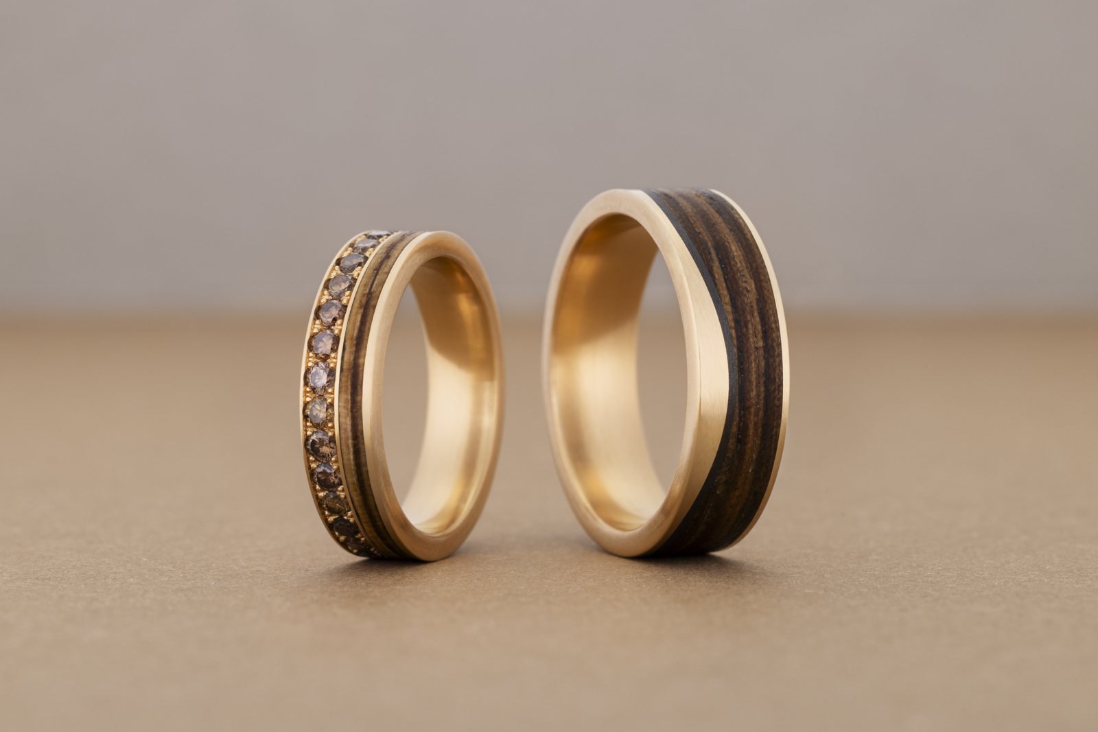 Zwei Bentwood-Eheringe aus Holz und Gold, eines mit Brillanten