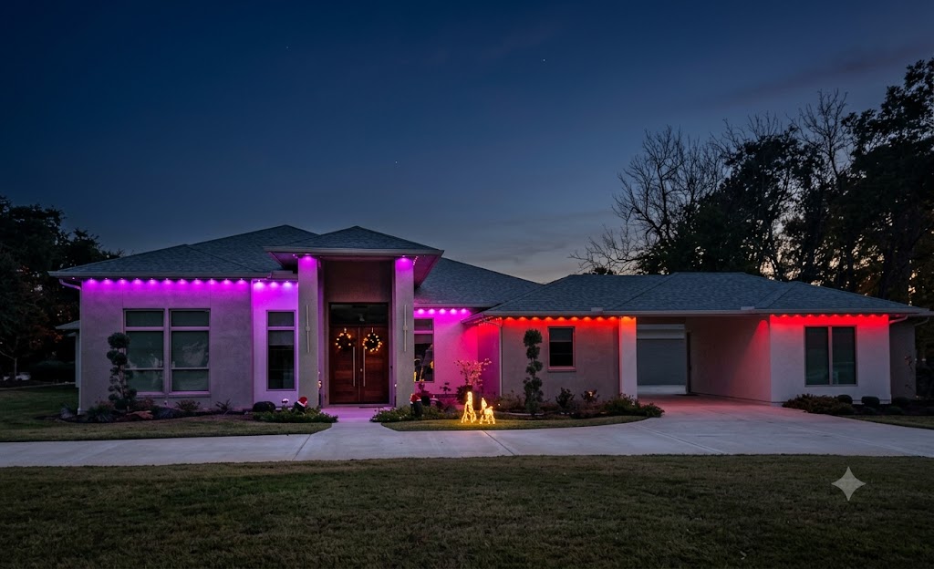 Permanent LED outdoor lighting installed along the roofline and eaves of a two-story residential home in Spring, TX. The fixtures illuminate the home's architectural features against a dark evening sky.
