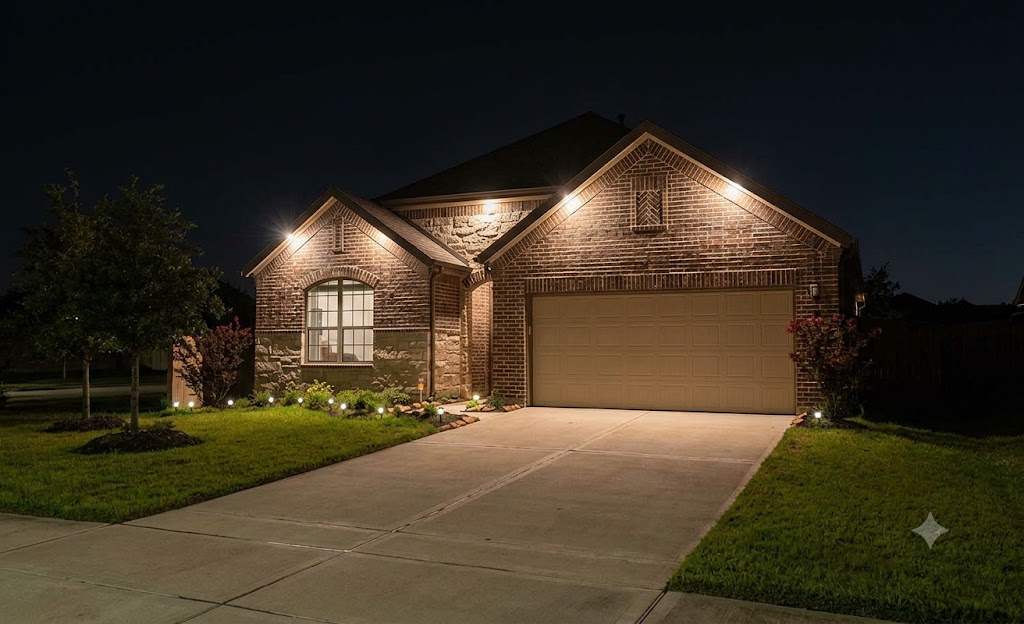 Exterior of a single-family home in Spring, TX with accent lighting illuminating the roofline, front columns, and landscaping at night. Low-voltage LED fixtures highlight the architectural details without visible wiring or glare.