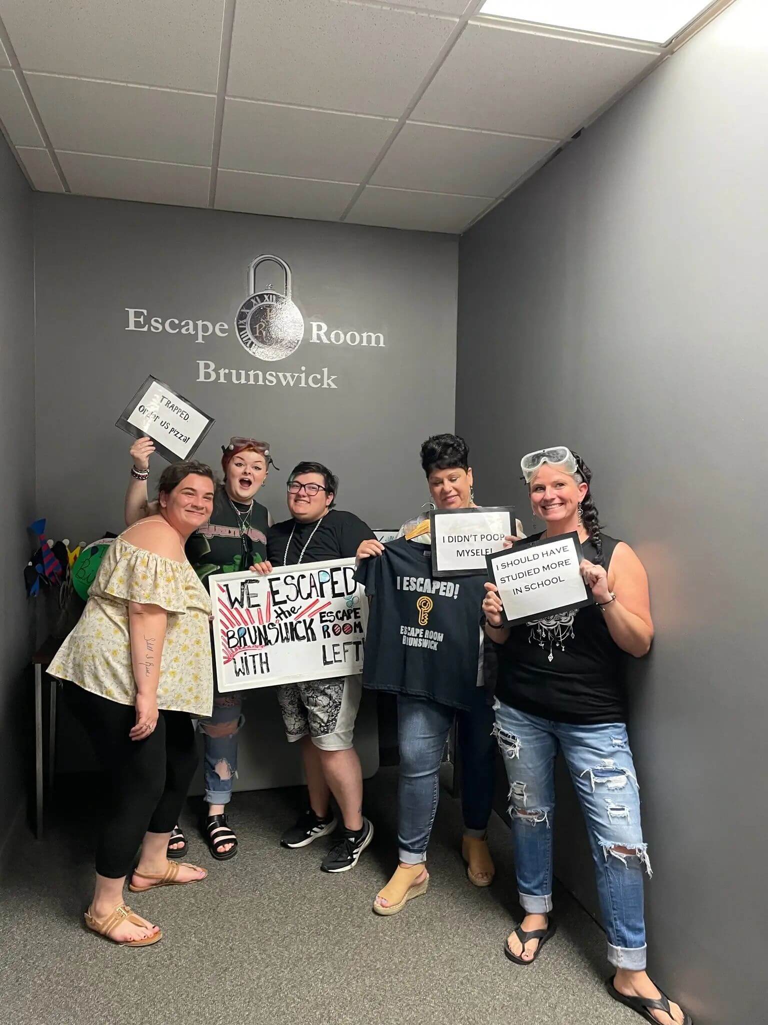 Great Hair in Maine team members posing together during a team-building escape room event, showing positive workplace environment.