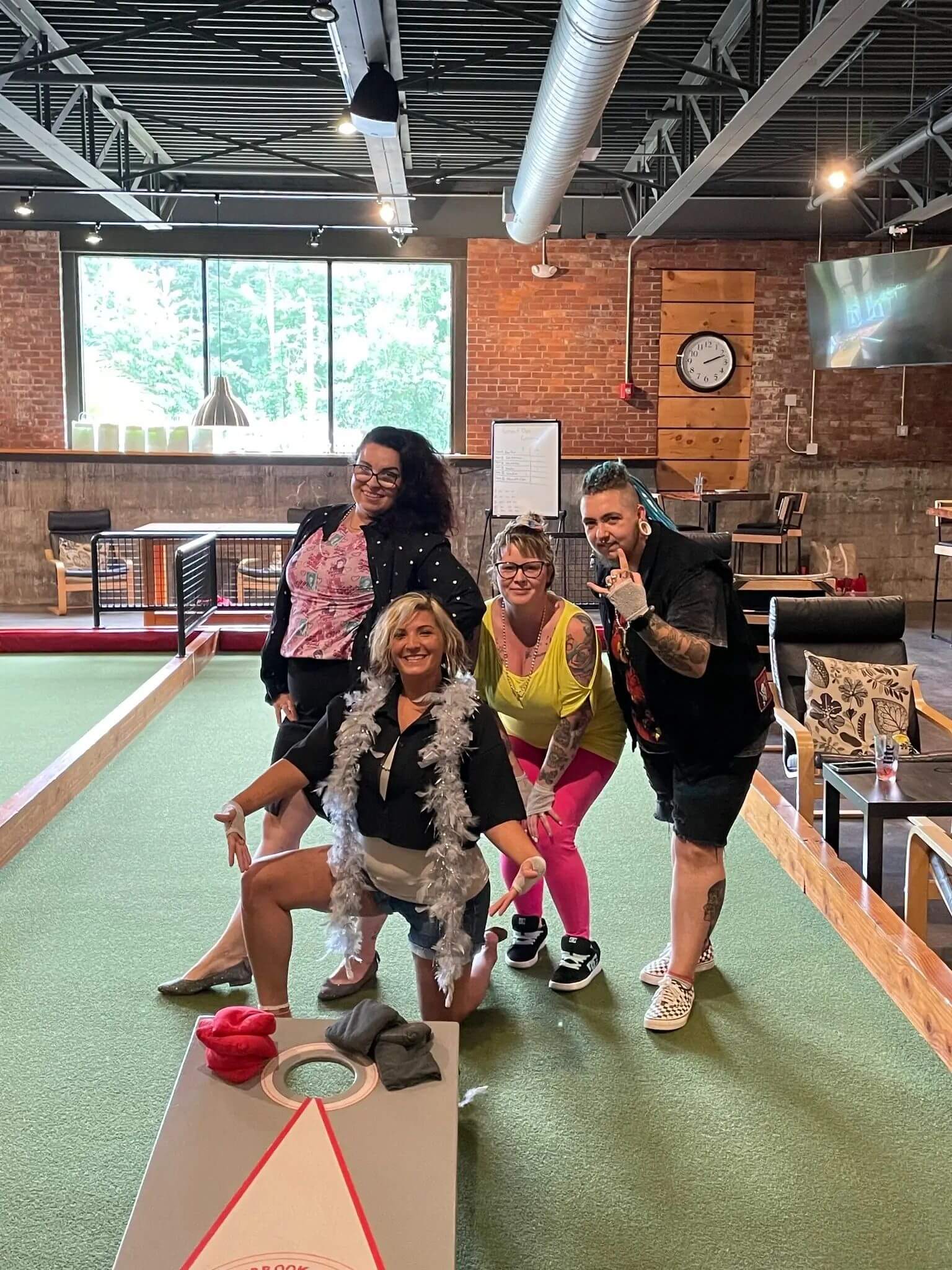 Salon team at Great Hair in Maine taking part in a corn hole tournament, highlighting a close-knit, family-run franchise atmosphere.