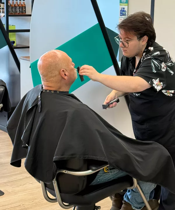 Licensed hairstylist cutting a client’s beard at Great Clips salon in Maine, highlighting flexible schedules, top pay, and supportive family-run salon culture.
