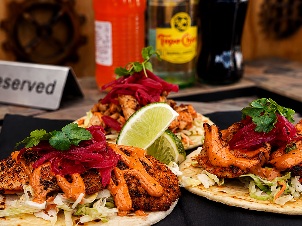 Shrimp and fish specialty tacos with pickled red onion